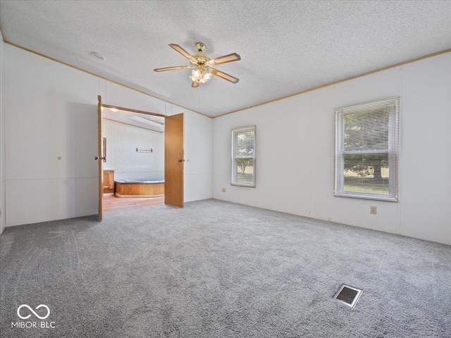 1447 NE Kutenai Trl, Greensburg, IN 47240 - carpeted spare room with a textured ceiling, lofted ceiling, ceiling fan, and crown molding