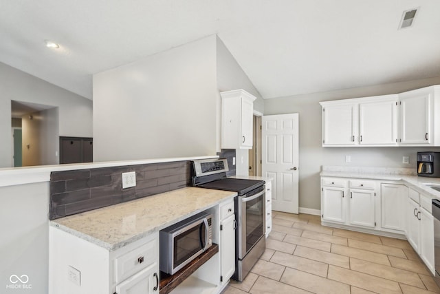 17357 Austrian Pine Way, Westfield, IN 46074 - kitchen featuring lofted ceiling, appliances with stainless steel finishes, white cabinetry, light stone countertops, and light tile patterned floors