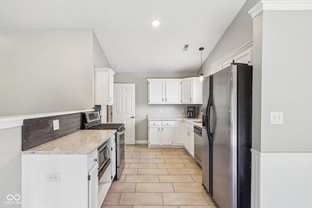 17357 Austrian Pine Way, Westfield, IN 46074 - kitchen with appliances with stainless steel finishes, white cabinetry, light stone counters, hanging light fixtures, and light tile patterned floors