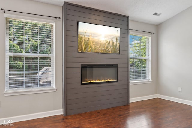 17357 Austrian Pine Way, Westfield, IN 46074 - unfurnished living room with wood finished floors, a fireplace, baseboards, and a textured ceiling