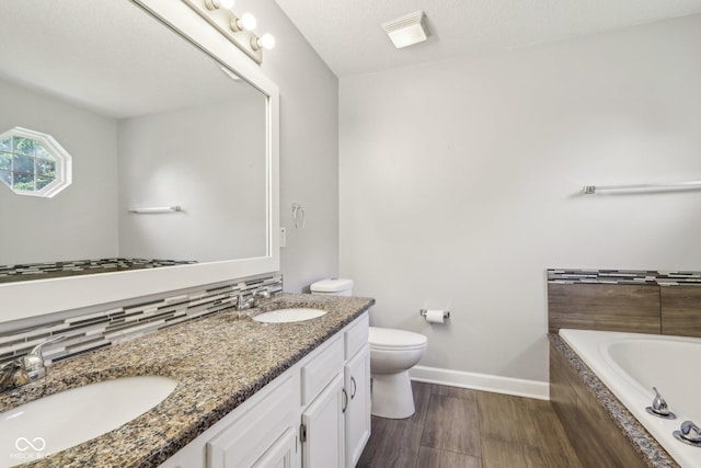 17357 Austrian Pine Way, Westfield, IN 46074 - full bathroom with tiled bath, double vanity, toilet, baseboards, and wood finished floors