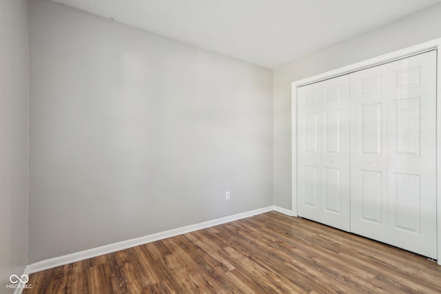 17357 Austrian Pine Way, Westfield, IN 46074 - unfurnished bedroom featuring dark wood-type flooring, baseboards, and a closet