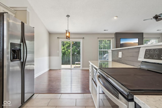 17357 Austrian Pine Way, Westfield, IN 46074 - kitchen featuring stainless steel appliances, hanging light fixtures, baseboards, light stone counters, and light tile patterned flooring