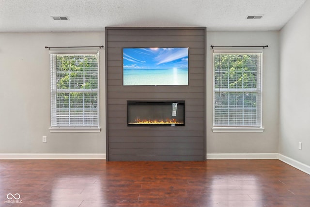 17357 Austrian Pine Way, Westfield, IN 46074 - unfurnished living room with wood finished floors, a textured ceiling, a fireplace, and baseboards