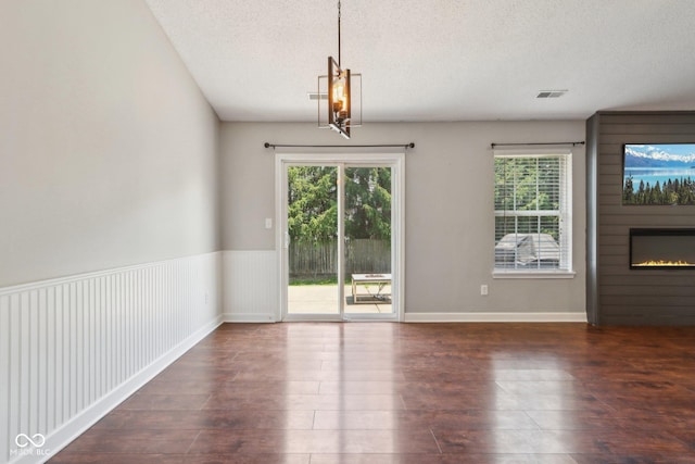 17357 Austrian Pine Way, Westfield, IN 46074 - unfurnished dining area featuring plenty of natural light, wood finished floors, a textured ceiling, and a large fireplace
