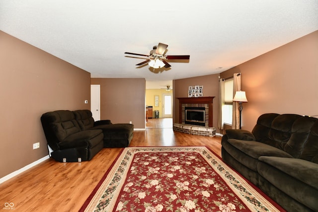 3429 Pavetto Ln, Indianapolis, IN 46203 - living room featuring a ceiling fan, light wood-style flooring, and a brick fireplace