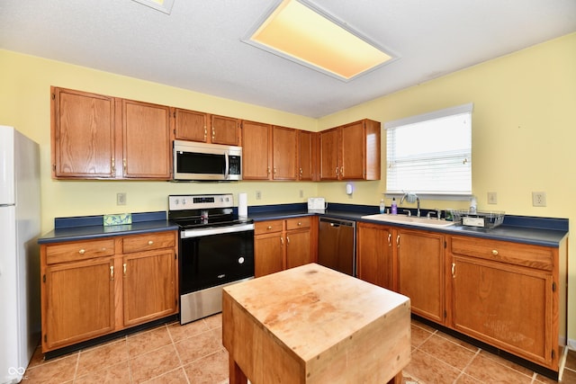 3429 Pavetto Ln, Indianapolis, IN 46203 - kitchen featuring stainless steel appliances, brown cabinets, and light tile patterned floors