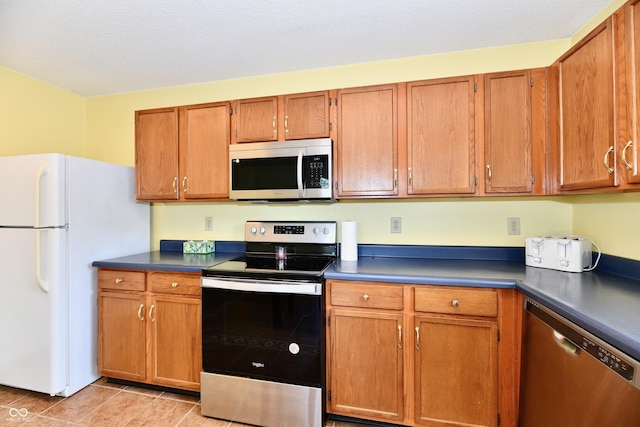 3429 Pavetto Ln, Indianapolis, IN 46203 - kitchen with appliances with stainless steel finishes, dark countertops, and brown cabinetry
