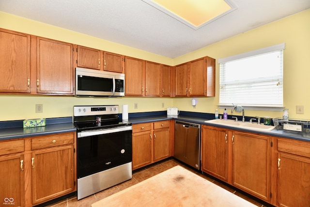 3429 Pavetto Ln, Indianapolis, IN 46203 - kitchen with appliances with stainless steel finishes, brown cabinetry, and dark countertops