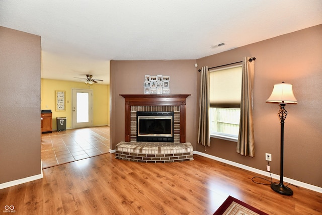3429 Pavetto Ln, Indianapolis, IN 46203 - living room featuring a brick fireplace, wood finished floors, and healthy amount of natural light