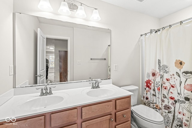 bathroom featuring double vanity, toilet, and curtained shower