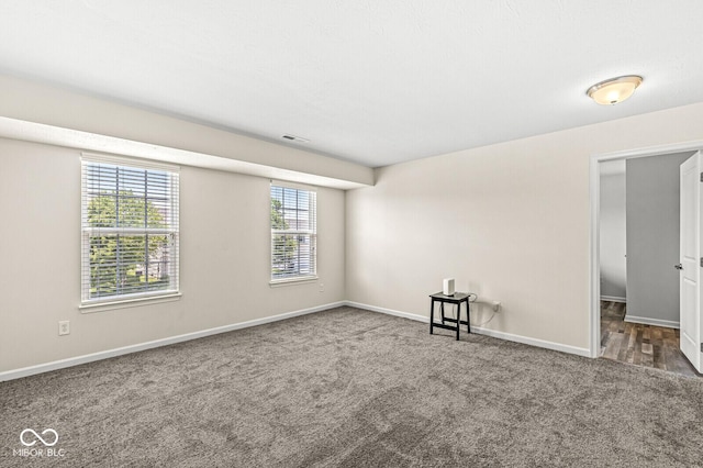 empty room featuring carpet flooring and baseboards