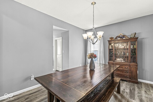 dining room with a chandelier, dark wood-style floors, and baseboards