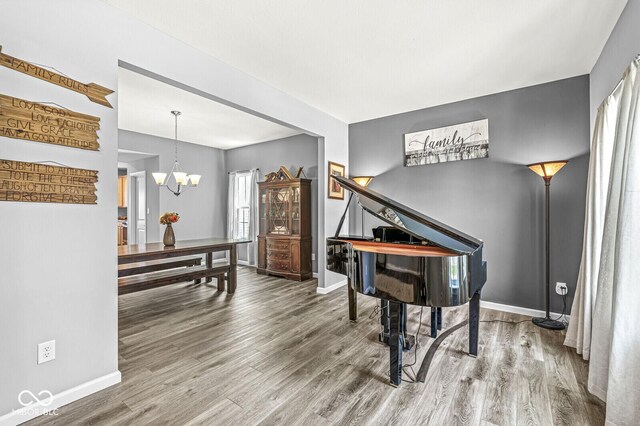 sitting room featuring wood finished floors, a chandelier, and baseboards