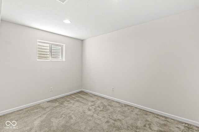 carpeted empty room featuring baseboards