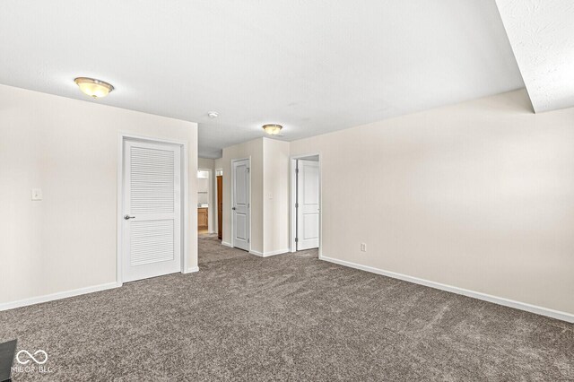 carpeted empty room featuring baseboards