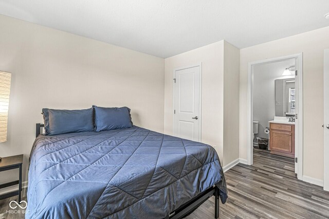 bedroom featuring wood finished floors and baseboards