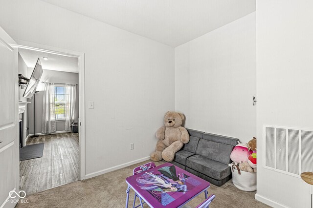 game room with carpet, baseboards, and a fireplace