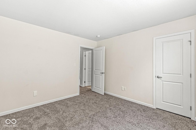 unfurnished bedroom with carpet flooring and baseboards