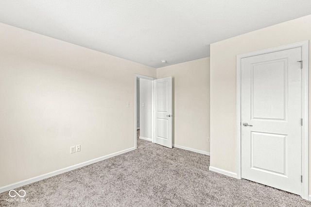 unfurnished bedroom with baseboards and carpet