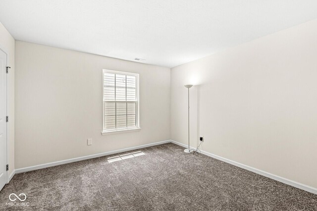 carpeted empty room featuring baseboards