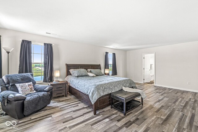 bedroom featuring wood finished floors and baseboards