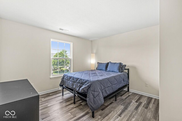 bedroom featuring wood finished floors and baseboards