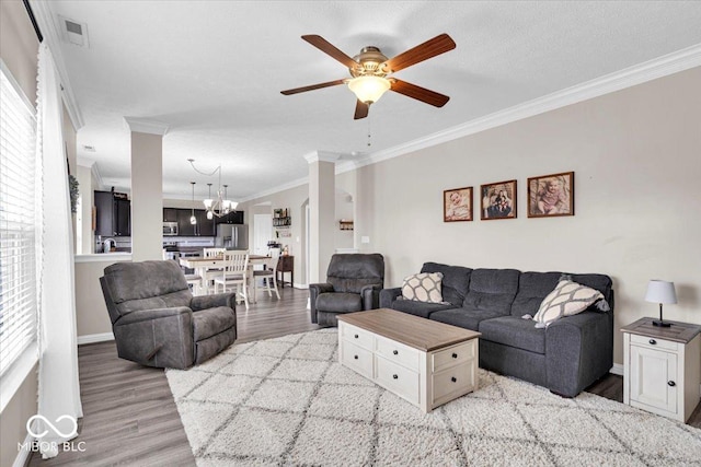 2434 Burgundy Way, Plainfield, IN 46168 - living room featuring crown molding, light wood-style floors, a chandelier, ceiling fan, and baseboards