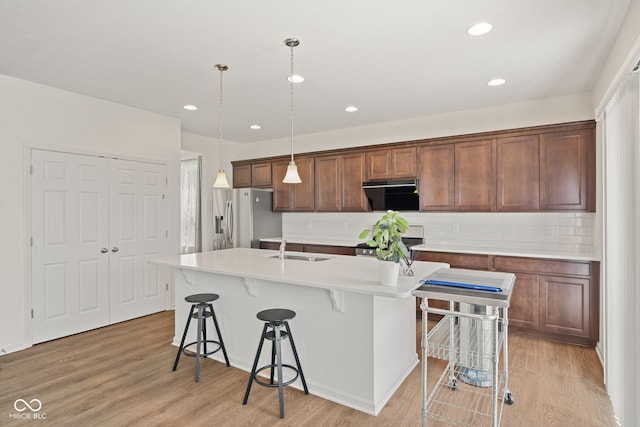1026 Sorrell Pass, Greenwood, IN 46143 - kitchen featuring stainless steel refrigerator with ice dispenser, a sink, stove, a kitchen bar, and a kitchen island with sink
