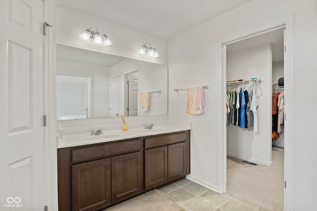1026 Sorrell Pass, Greenwood, IN 46143 - bathroom featuring double vanity, a walk in closet, baseboards, and tile patterned flooring