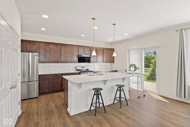 1026 Sorrell Pass, Greenwood, IN 46143 - kitchen with stainless steel appliances, wood finished floors, an island with sink, light countertops, and recessed lighting