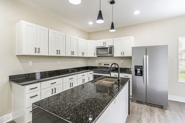 2427 N Rural St, Indianapolis, IN 46218 - kitchen with appliances with stainless steel finishes, light wood-style flooring, a sink, an island with sink, and white cabinets
