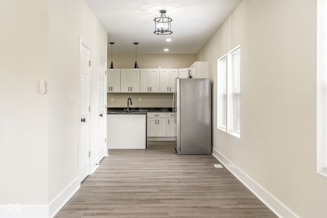 2427 N Rural St, Indianapolis, IN 46218 - kitchen with freestanding refrigerator, dark countertops, light wood finished floors, and recessed lighting