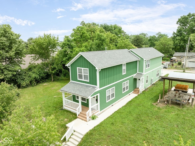 2427 N Rural St, Indianapolis, IN 46218 - rear view of property with board and batten siding, a shingled roof, covered porch, a lawn, and view of scattered trees