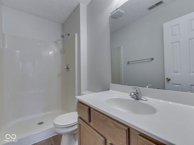 824 Ashton Park Dr, Greenwood, IN 46143 - bathroom featuring a textured ceiling, vanity, toilet, a shower, and wood finished floors