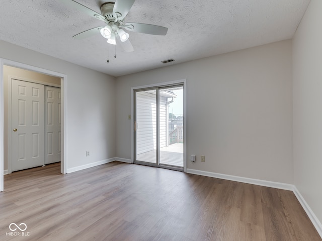 824 Ashton Park Dr, Greenwood, IN 46143 - unfurnished bedroom featuring access to exterior, wood finished floors, baseboards, and a textured ceiling