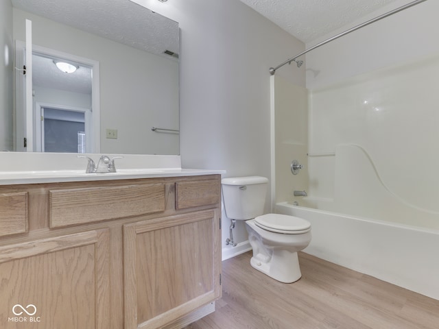 824 Ashton Park Dr, Greenwood, IN 46143 - bathroom featuring a textured ceiling, toilet, vanity, wood finished floors, and shower / bathtub combination