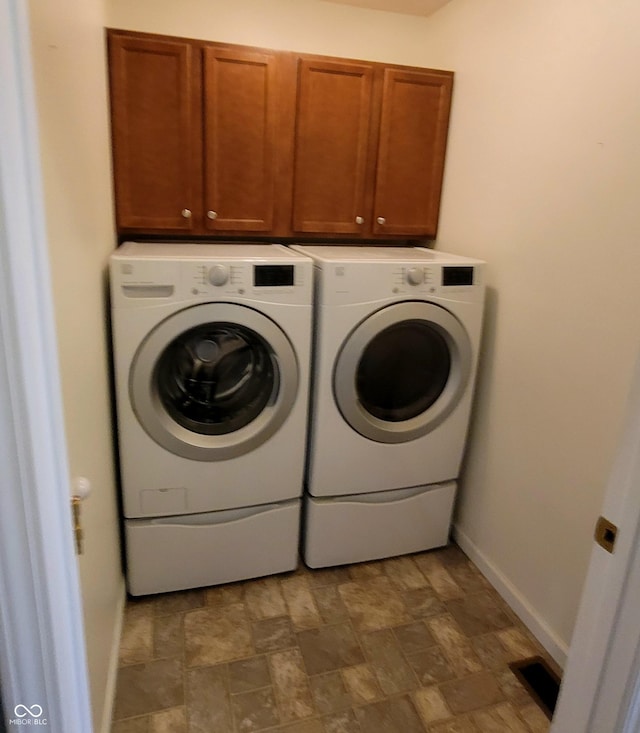 1306 W Daniel Dr, Greensburg, IN 47240 - laundry area featuring washer and dryer, cabinet space, baseboards, and stone finish floors
