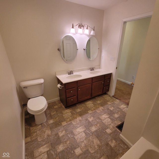1306 W Daniel Dr, Greensburg, IN 47240 - full bath featuring stone finish floors, double vanity, baseboards, and toilet