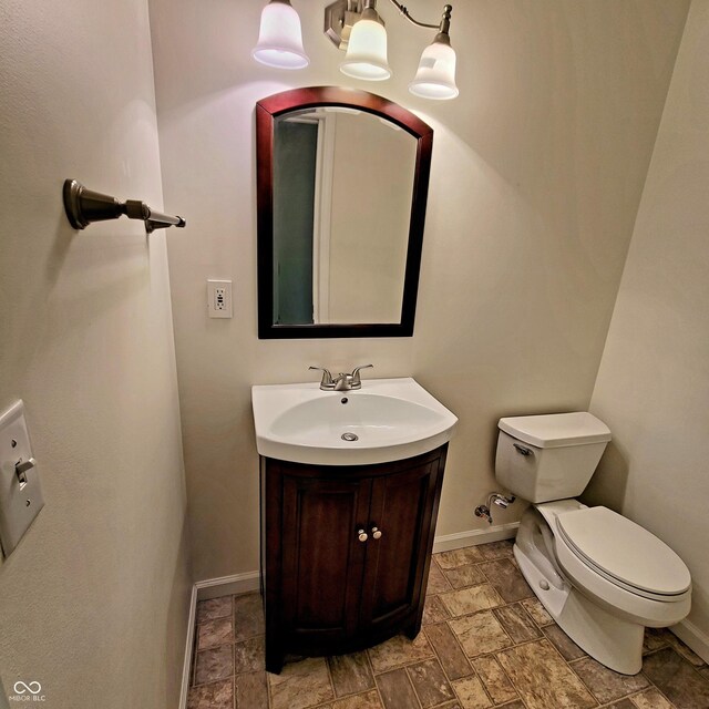 1306 W Daniel Dr, Greensburg, IN 47240 - half bathroom with toilet, vanity, baseboards, and stone finish floors