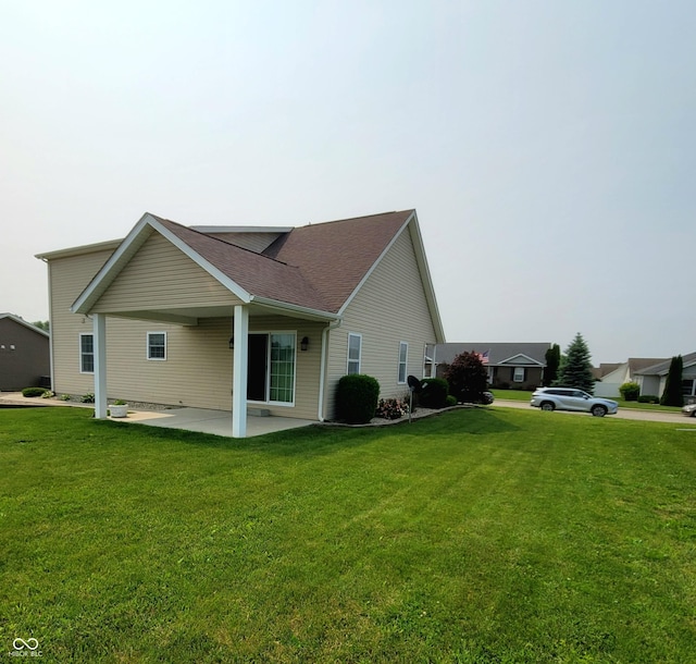 1306 W Daniel Dr, Greensburg, IN 47240 - view of home's exterior with a patio area, a lawn, and roof with shingles