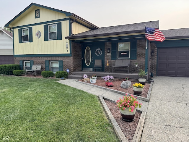 4928 Dancer Dr, Indianapolis, IN 46237 - split level home featuring brick siding, a front yard, covered porch, and roof with shingles