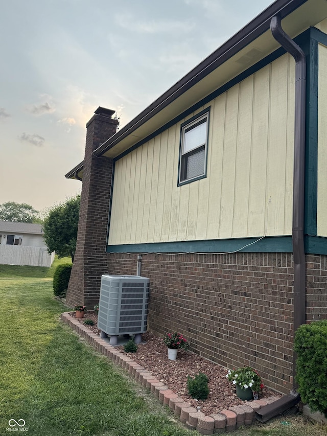 4928 Dancer Dr, Indianapolis, IN 46237 - view of side of home with central AC unit, a chimney, a lawn, and brick siding