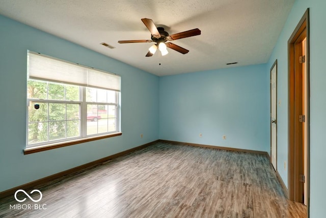 12157 Longstraw Dr, Indianapolis, IN 46236 - unfurnished room with wood finished floors, ceiling fan, baseboards, and a textured ceiling