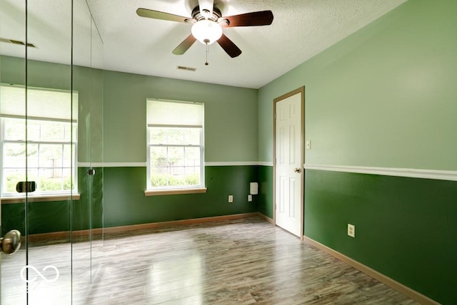 12157 Longstraw Dr, Indianapolis, IN 46236 - unfurnished room featuring healthy amount of natural light, wood finished floors, a textured ceiling, a ceiling fan, and baseboards