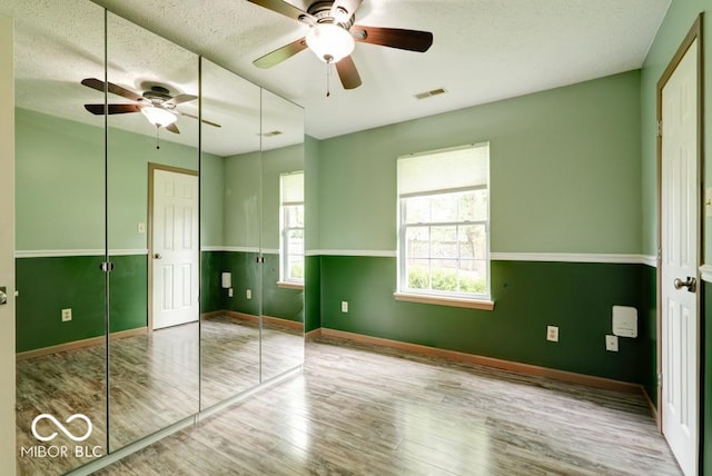 12157 Longstraw Dr, Indianapolis, IN 46236 - unfurnished bedroom featuring wood finished floors, baseboards, a textured ceiling, a closet, and ceiling fan