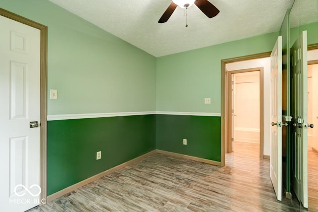 12157 Longstraw Dr, Indianapolis, IN 46236 - spare room featuring wood finished floors, a ceiling fan, a textured ceiling, and baseboards