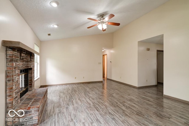 12157 Longstraw Dr, Indianapolis, IN 46236 - unfurnished living room with wood finished floors, lofted ceiling, a fireplace, ceiling fan, and baseboards