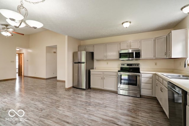 12157 Longstraw Dr, Indianapolis, IN 46236 - kitchen featuring appliances with stainless steel finishes, a sink, light wood-style floors, ceiling fan, and light countertops