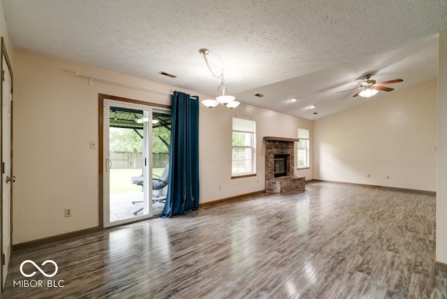 12157 Longstraw Dr, Indianapolis, IN 46236 - unfurnished living room featuring wood finished floors, healthy amount of natural light, baseboards, a textured ceiling, and vaulted ceiling